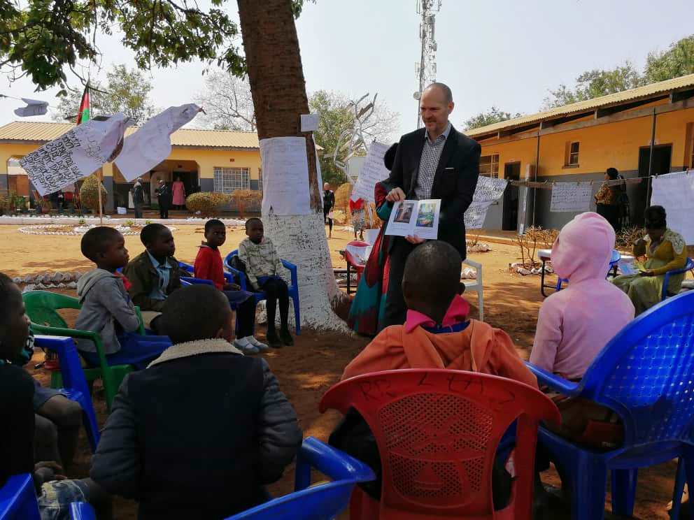 Jeremy with Students - YESA Chief of Party, Jeremy Koch, reads to Standard 3 students during the International Literacy Day event.